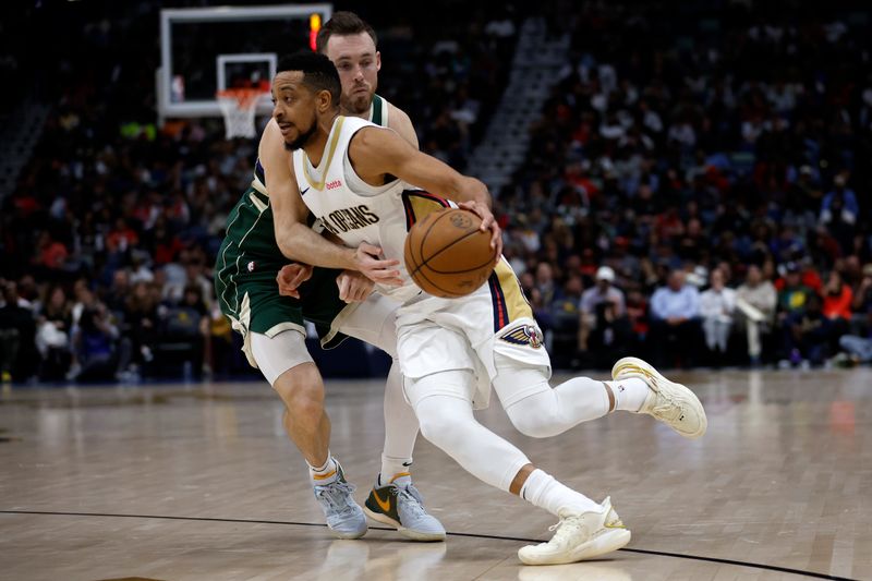 NEW ORLEANS, LOUISIANA - MARCH 28: CJ McCollum #3 of the New Orleans Pelicans drives the ball around Pat Connaughton #24 of the Milwaukee Bucks at Smoothie King Center on March 28, 2024 in New Orleans, Louisiana. NOTE TO USER: User expressly acknowledges and agrees that, by downloading and or using this photograph, User is consenting to the terms and conditions of the Getty Images License Agreement.  (Photo by Chris Graythen/Getty Images)