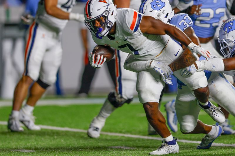 Oct 21, 2023; Chapel Hill, North Carolina, USA; Virginia Cavaliers running back Mike Hollins (7) fights for yards as he is tackled by North Carolina Tar Heels linebacker Cedric Gray (33) in the second half at Kenan Memorial Stadium. Mandatory Credit: Nell Redmond-USA TODAY Sports