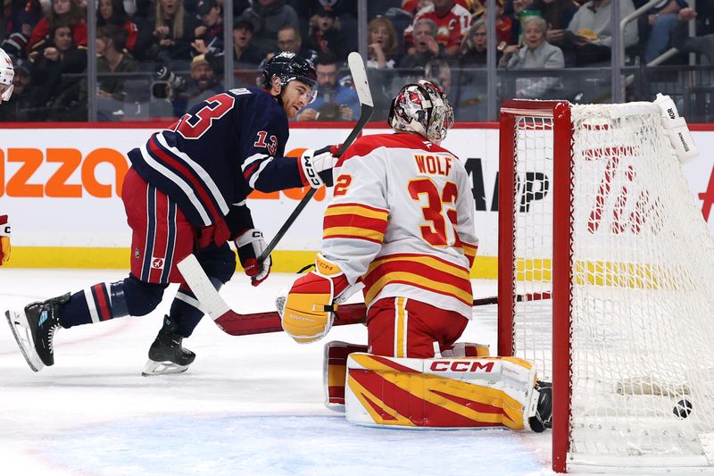 Oct 24, 2025; Winnipeg, Manitoba, CAN; Winnipeg Jets center Gabriel Vilardi (13) scores on Calgary Flames goaltender Dustin Wolf (32) in the second period at Canada Life Centre. Mandatory Credit: James Carey Lauder-Imagn Images
