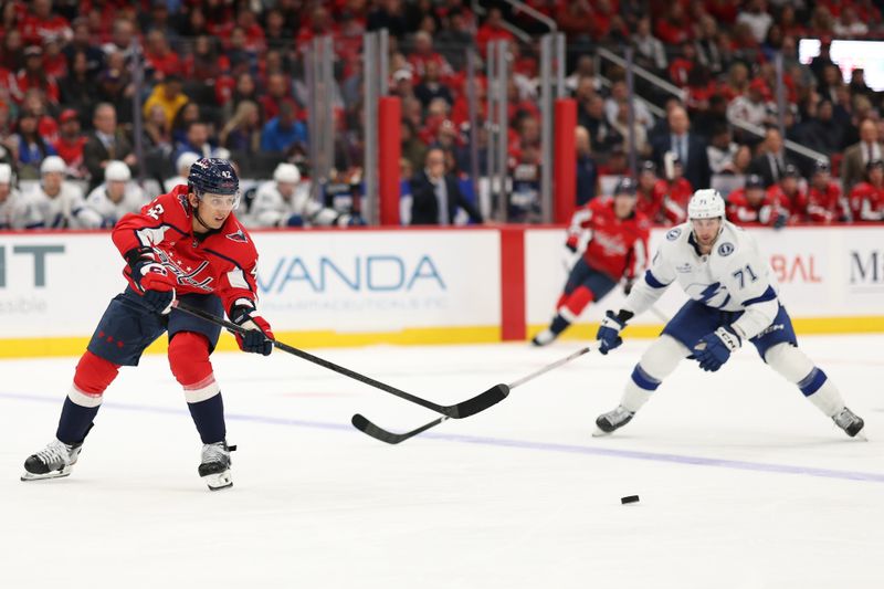 Oct 14, 2025; Washington, District of Columbia, USA; Washington Capitals defenseman Martin Fehérváry (42) passes the puck as /Tampa Bay Lightning center Anthony Cirelli (71) defends in the second period at Capital One Arena. Mandatory Credit: Geoff Burke-Imagn Images