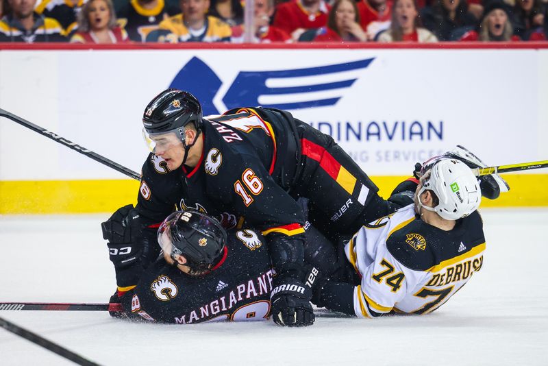 Feb 28, 2023; Calgary, Alberta, CAN; Calgary Flames defenseman Nikita Zadorov (16) and left wing Andrew Mangiapane (88) collide with Boston Bruins left wing Jake DeBrusk (74) during the third period at Scotiabank Saddledome. Mandatory Credit: Sergei Belski-USA TODAY Sports