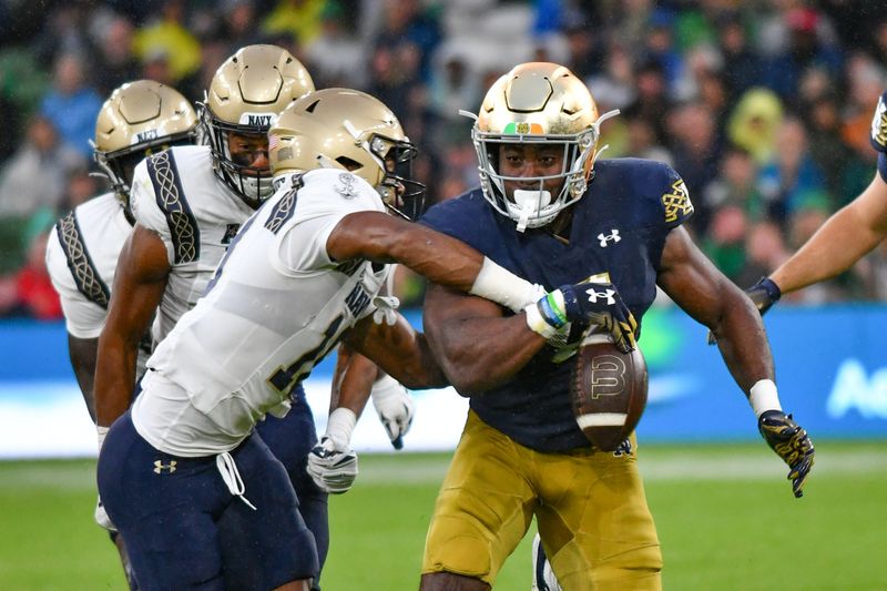 Aug 26, 2023; Dublin, IRL; Navy Midshipmen safety Rayuan Lane III (18) knocks the ball away from Notre Dame Fighting Irish running back Audric Estime (7) in the first quarter at Aviva Stadium. Mandatory Credit: Matt Cashore-USA TODAY Sports