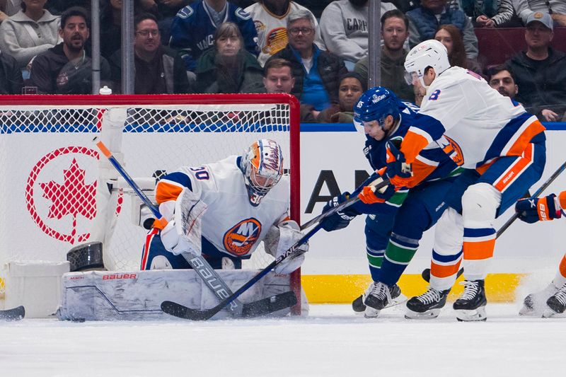 Nov 15, 2023; Vancouver, British Columbia, CAN; New York Islanders defenseman Noah Dobson (8) watches as goalie Ilya Sorokin (30) makes a save on Vancouver Canucks forward Ilya Mikheyev (65) in the first period at Rogers Arena. Mandatory Credit: Bob Frid-USA TODAY Sports