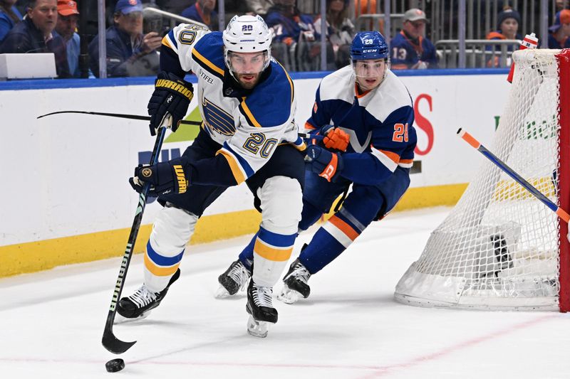 Mar 5, 2024; Elmont, New York, USA;  St. Louis Blues left wing Brandon Saad (20) skates the puck from behind the net chased by New York Islanders defenseman Sebastian Aho (25) during the first period at UBS Arena. Mandatory Credit: Dennis Schneidler-USA TODAY Sports