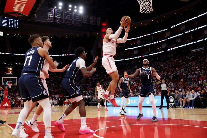 HOUSTON, TEXAS - DECEMBER 22: Dillon Brooks #9 of the Houston Rockets shoots the ball while defended by Olivier-Maxence Prosper #18 of the Dallas Mavericks and Jaden Hardy #1 in the second half at Toyota Center on December 22, 2023 in Houston, Texas.   NOTE TO USER: User expressly acknowledges and agrees that, by downloading and or using this photograph, User is consenting to the terms and conditions of the Getty Images License Agreement. (Photo by Tim Warner/Getty Images)