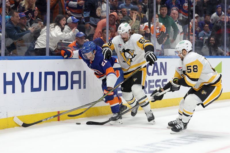 Nov 5, 2024; Elmont, New York, USA; New York Islanders center Kyle Palmieri (21) fights for the puck against Pittsburgh Penguins defensemen Erik Karlsson (65) and Kris Letang (58) during overtime at UBS Arena. Mandatory Credit: Brad Penner-Imagn Images