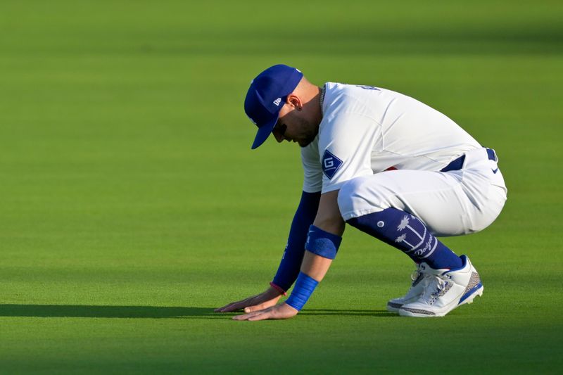 Oct 5, 2024; Los Angeles, California, USA; Los Angeles Dodgers short stop Miguel Rojas (11) stretches before playing against the San Diego Padres in game one of the NLDS for the 2024 MLB Playoffs at Dodger Stadium. Mandatory Credit: Jayne Kamin-Oncea-Imagn Images