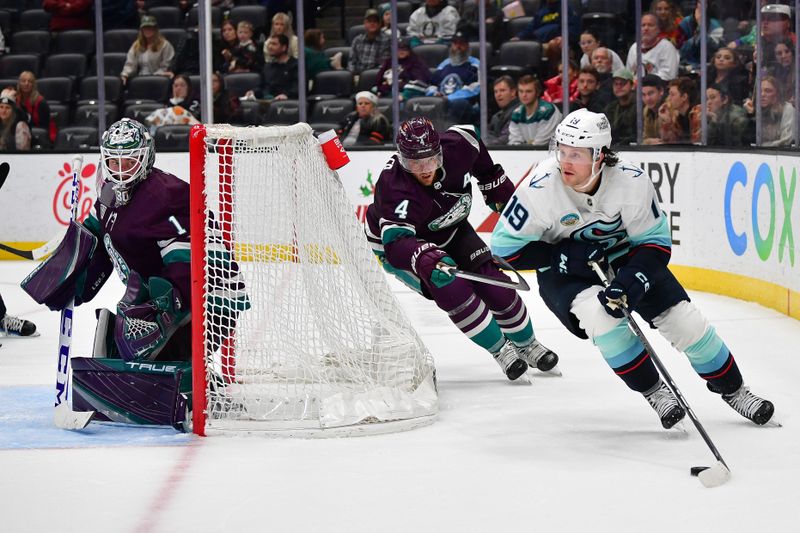 Dec 23, 2023; Anaheim, California, USA; Seattle Kraken left wing Jared McCann (19) moves the puck as Anaheim Ducks defenseman Cam Fowler (4) helps goaltender Lukas Dostal (1) defend the goal during the third period at Honda Center. Mandatory Credit: Gary A. Vasquez-USA TODAY Sports