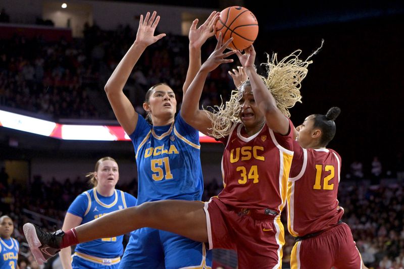 Jan 14, 2024; Los Angeles, California, USA; UCLA Bruins center Lauren Betts (51), USC Trojans center Clarice Akunwafo (34) and guard JuJu Watkins (12) go for a rebound in the first half at Galen Center. Mandatory Credit: Jayne Kamin-Oncea-USA TODAY Sports