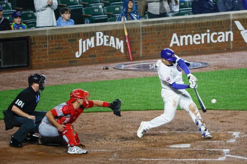 Jun 1, 2024; Chicago, Illinois, USA; Chicago Cubs outfielder Seiya Suzuki (27) hits a grand slam against the Cincinnati Reds during the second inning at Wrigley Field. Mandatory Credit: Kamil Krzaczynski-USA TODAY Sports