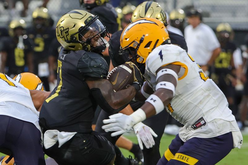 Aug 31, 2023; Orlando, Florida, USA; UCF Knights running back RJ Harvey (7) is tackled by Kent State Golden Flashes linebacker CJ Harris (37) during the first quarter at FBC Mortgage Stadium. Mandatory Credit: Mike Watters-USA TODAY Sports battle for the ball