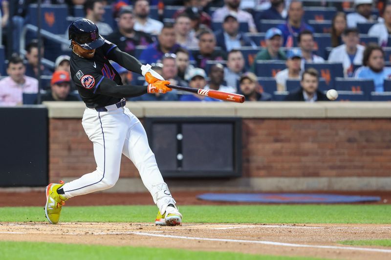 Apr 22, 2025; New York City, New York, USA;  New York Mets shortstop Francisco Lindor (12) hits a single in the first inning against the Philadelphia Phillies at Citi Field. Mandatory Credit: Wendell Cruz-Imagn Images
