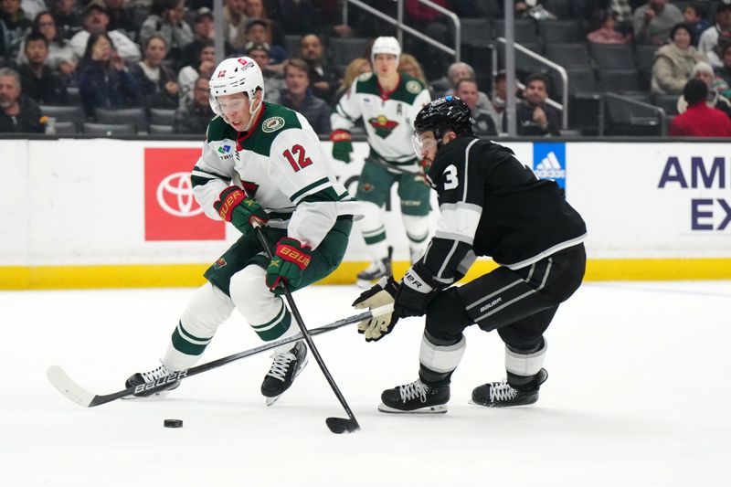 Apr 15, 2024; Los Angeles, California, USA; Minnesota Wild left wing Matt Boldy (12) and LA Kings defenseman Matt Roy (3) battle for the puck in the first period at Crypto.com Arena. Mandatory Credit: Kirby Lee-USA TODAY Sports