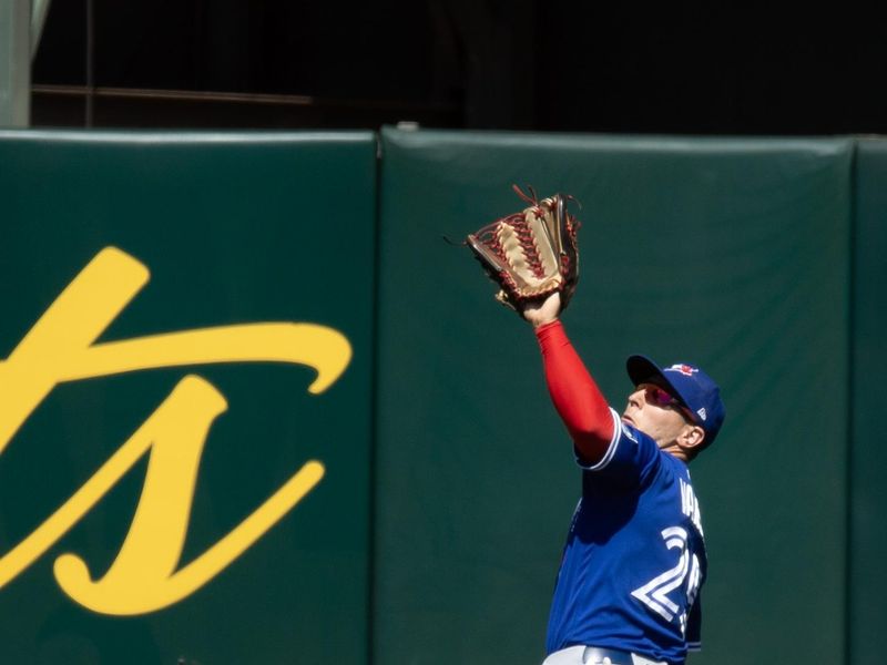 Sep 6, 2023; Oakland, California, USA; Toronto Blue Jays center fielder Daulton Varsho (25) makes a running catch of a fly ball by Oakland Athletics center fielder Esteury Ruiz during the sixth inning at Oakland-Alameda County Coliseum. Mandatory Credit: D. Ross Cameron-USA TODAY Sports