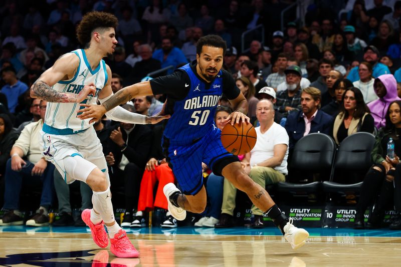 CHARLOTTE, NORTH CAROLINA - NOVEMBER 25: Cole Anthony #50 of the Orlando Magic drives by LaMelo Ball #1 of the Charlotte Hornets during the second half of a basketball game at Spectrum Center on November 25, 2024 in Charlotte, North Carolina. NOTE TO USER: User expressly acknowledges and agrees that, by downloading and or using this photograph, User is consenting to the terms and conditions of the Getty Images License Agreement. (Photo by David Jensen/Getty Images)