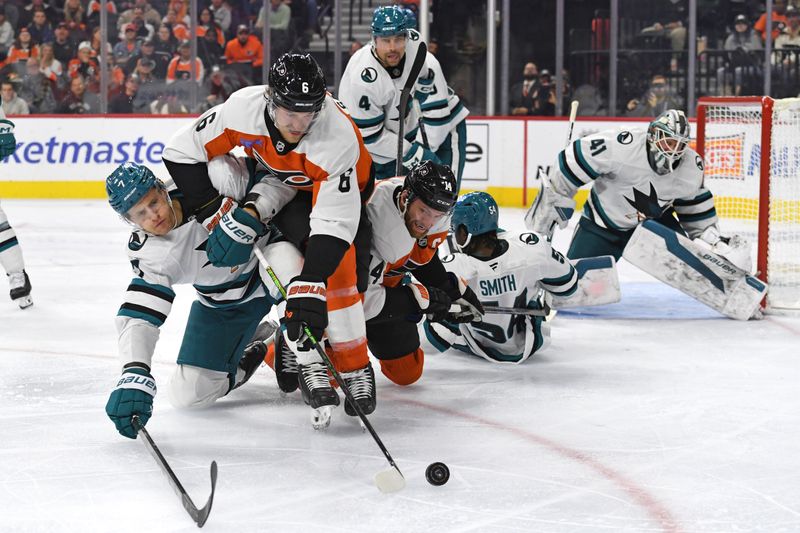 Nov 11, 2024; Philadelphia, Pennsylvania, USA; Philadelphia Flyers defenseman Travis Sanheim (6) reaches for the puck with San Jose Sharks center Nico Sturm (7) during the third period at Wells Fargo Center. Mandatory Credit: Eric Hartline-Imagn Images