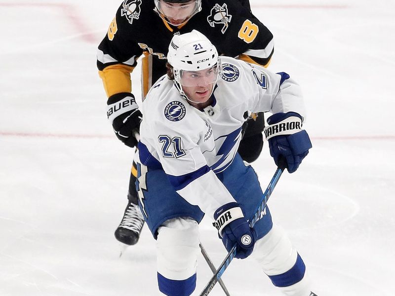 Nov 19, 2024; Pittsburgh, Pennsylvania, USA; Tampa Bay Lightning center Brayden Point (21) moves the puck as Pittsburgh Penguins left wing Michael Bunting (8) chases during the second period at PPG Paints Arena. Mandatory Credit: Charles LeClaire-Imagn Images