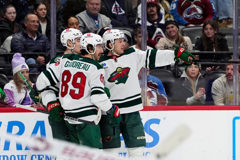 Jan 20, 2025; Denver, Colorado, USA; Minnesota Wild defenseman Brock Faber (7) (right) celebrates his goal with center Frederick Gaudreau (89) and left wing Liam Ohgren (28)  in the third period against the Colorado Avalanche at Ball Arena. Mandatory Credit: Ron Chenoy-Imagn Images