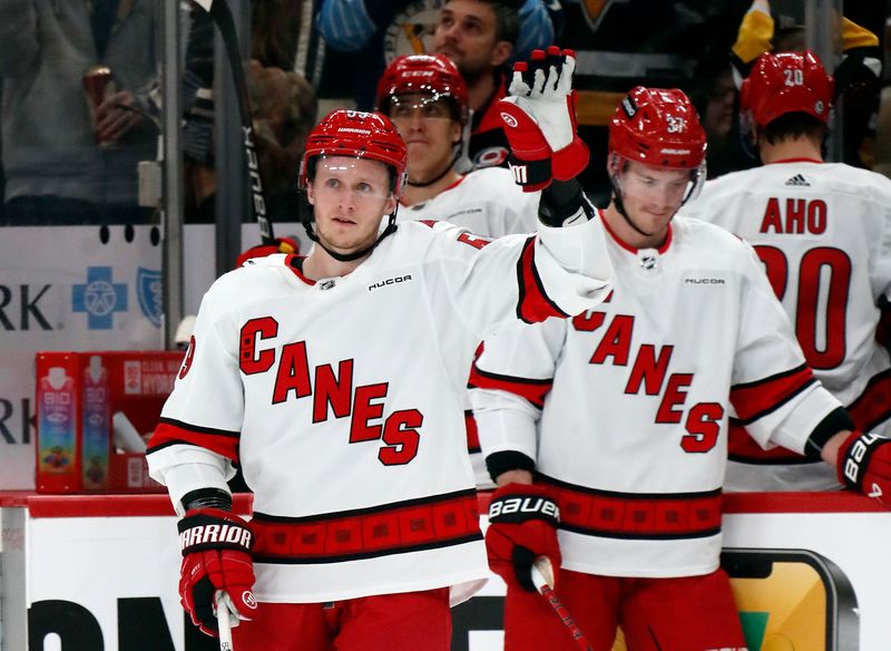 Mar 26, 2024; Pittsburgh, Pennsylvania, USA; Carolina Hurricanes left wing Jake Guentzel (left) waves to the crowd as a video board tribute in honor of his time with the Pittsburgh Penguins plays during the first period at PPG Paints Arena. Mandatory Credit: Charles LeClaire-USA TODAY Sports