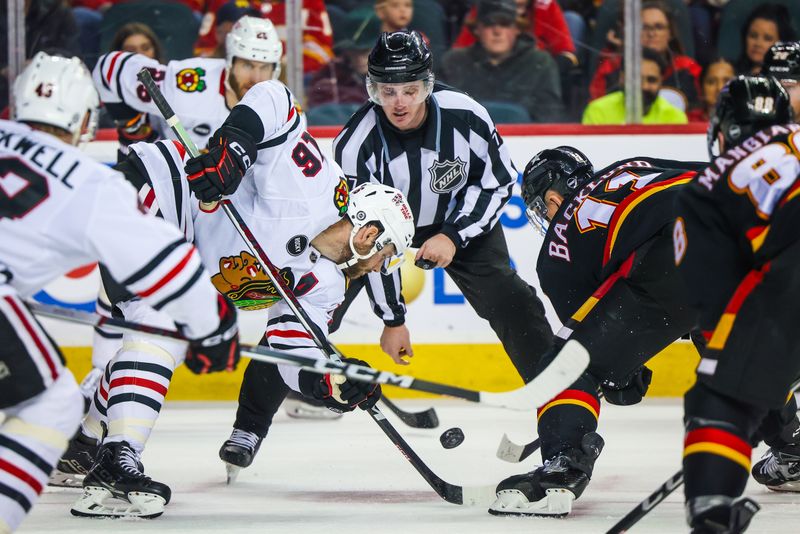 Jan 27, 2024; Calgary, Alberta, CAN; Chicago Blackhawks center Jason Dickinson (16) and Calgary Flames center Mikael Backlund (11) face off for the puck during the second period at Scotiabank Saddledome. Mandatory Credit: Sergei Belski-USA TODAY Sports