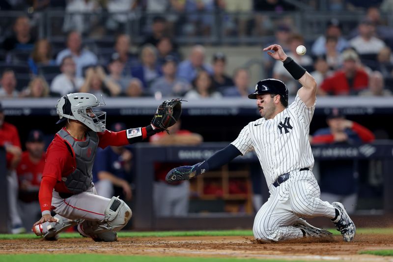 Jun 6, 2025; Bronx, New York, USA; New York Yankees catcher Austin Wells (28) scores against Boston Red Sox catcher Carlos Narvaez (75) on a double by Yankees right fielder Aaron Judge (99) during the fifth inning at Yankee Stadium. Mandatory Credit: Brad Penner-Imagn Images