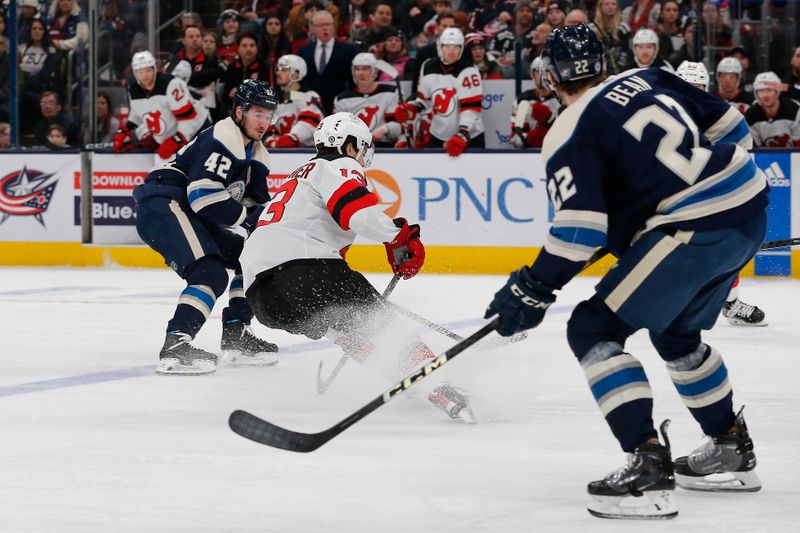 Jan 19, 2024; Columbus, Ohio, USA; New Jersey Devils center Nico Hischier (13) grabs a loose puck against the Columbus Blue Jackets during the second period at Nationwide Arena. Mandatory Credit: Russell LaBounty-USA TODAY Sports