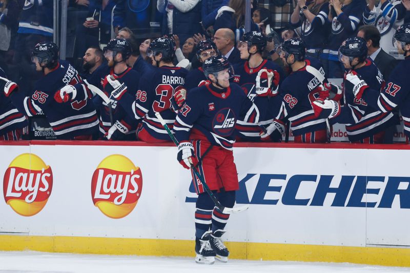 Oct 18, 2024; Winnipeg, Manitoba, CAN;  Winnipeg Jets forward Nikolaj Ehlers (27) is congratulated by his teammates on his goal against the San Jose Sharks during the first period at Canada Life Centre. Mandatory Credit: Terrence Lee-Imagn Images