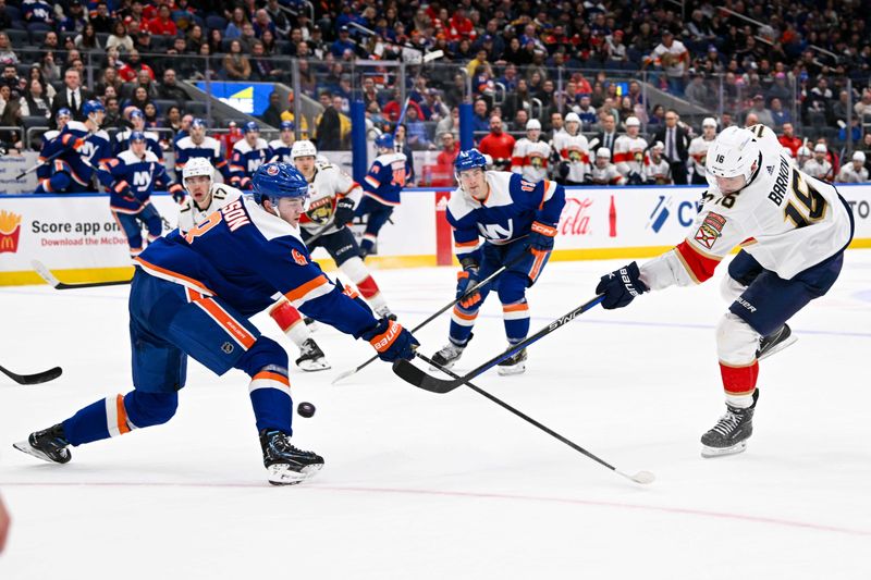 Jan 27, 2024; Elmont, New York, USA; New York Islanders defenseman Noah Dobson (8) defends against the shot by Florida Panthers center Aleksander Barkov (16) during the third period at UBS Arena. Mandatory Credit: Dennis Schneidler-USA TODAY Sports