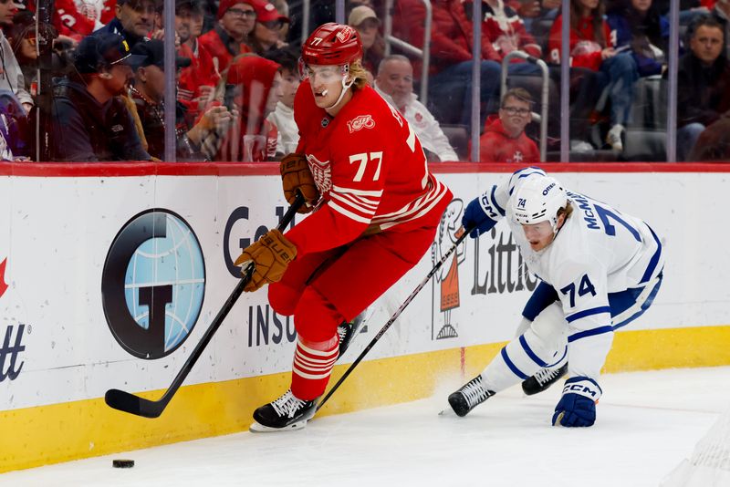 Dec 28, 2025; Detroit, Michigan, USA;  Detroit Red Wings defenseman Simon Edvinsson (77) skates with the puck defended by Toronto Maple Leafs center Bobby McMann (74) in the first period at Little Caesars Arena. Mandatory Credit: Rick Osentoski-Imagn Images