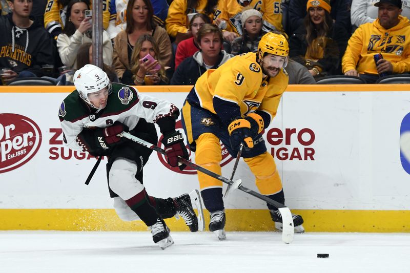 Nov 11, 2023; Nashville, Tennessee, USA; Nashville Predators left wing Filip Forsberg (9) and Arizona Coyotes right wing Clayton Keller (9) battle for the puck during the second period at Bridgestone Arena. Mandatory Credit: Christopher Hanewinckel-USA TODAY Sports