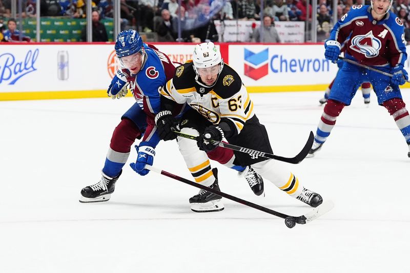 Oct 16, 2024; Denver, Colorado, USA; Colorado Avalanche defenseman Cale Makar (8) pokes the puck away from Boston Bruins left wing Brad Marchand (63) in the third period at Ball Arena. Mandatory Credit: Ron Chenoy-Imagn Images