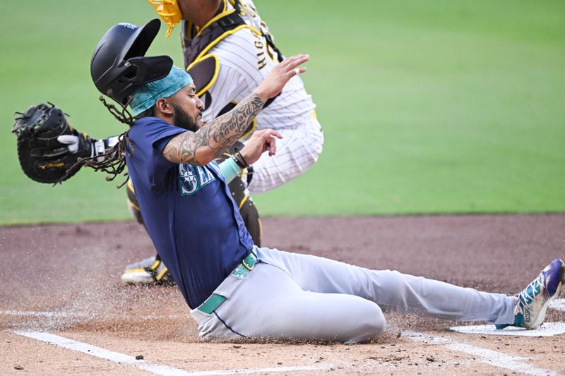 Jun 9, 2024; San Diego, California, USA; Seattle Mariners shortstop J.P. Crawford (3) scores ahead of the throw to San Diego Padres catcher Kyle Higashioka (20) during the first inning at Petco Park. Mandatory Credit: Denis Poroy-USA TODAY Sports at Petco Park. 