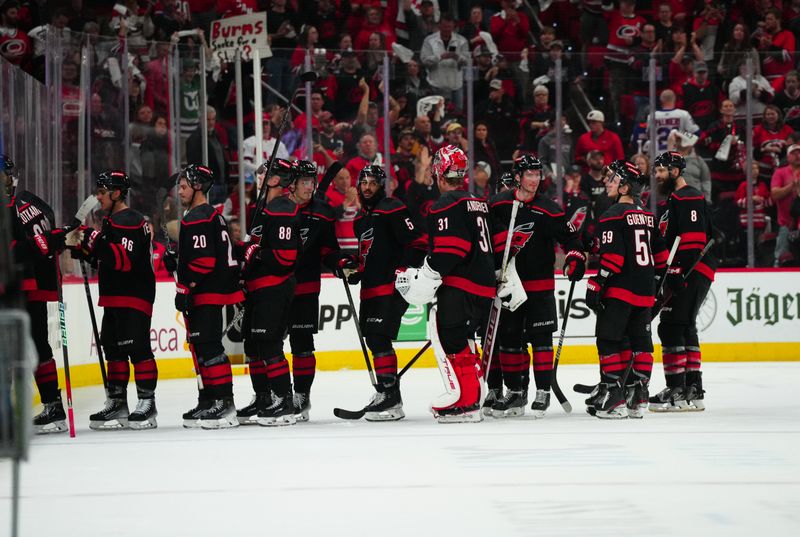 Apr 30, 2024; Raleigh, North Carolina, USA; Carolina Hurricanes players celebrate their victory against the New York Islanders  in game five of the first round of the 2024 Stanley Cup Playoffs at PNC Arena. Mandatory Credit: James Guillory-USA TODAY Sports