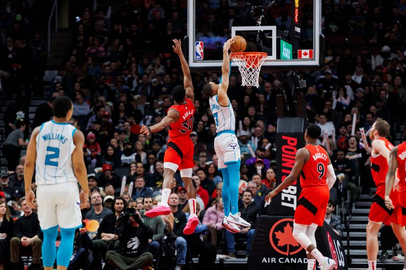 TORONTO, CANADA - MARCH 3: Bryce McGowens #7 of the Charlotte Hornets dunks against Ochai Agbaji #30 of the Toronto Raptors in the first half of their NBA game at Scotiabank Arena on March 3, 2024 in Toronto, Canada. NOTE TO USER: User expressly acknowledges and agrees that, by downloading and or using this photograph, User is consenting to the terms and conditions of the Getty Images License Agreement. (Photo by Cole Burston/Getty Images)