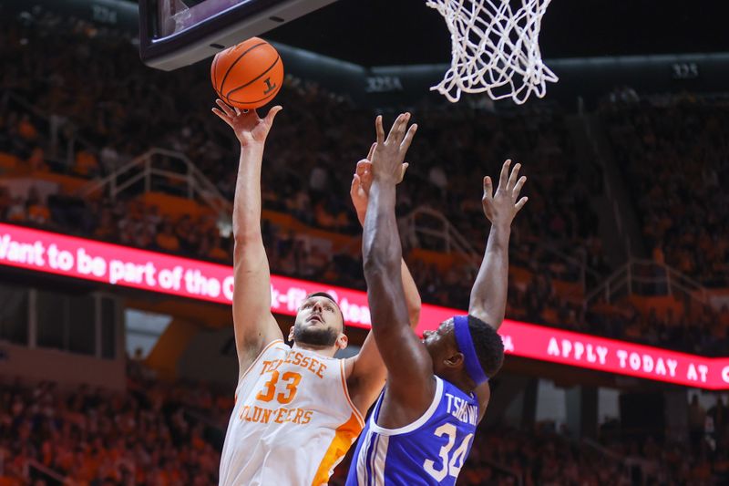 Jan 14, 2023; Knoxville, Tennessee, USA; Tennessee Volunteers forward Uros Plavsic (33) shoots the ball against Kentucky Wildcats forward Oscar Tshiebwe (34) during the first half at Thompson-Boling Arena. Mandatory Credit: Randy Sartin-USA TODAY Sports