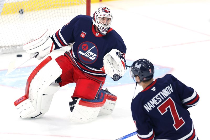 Nov 9, 2024; Winnipeg, Manitoba, CAN; Winnipeg Jets goaltender Connor Hellebuyck (37) gloves the puck from a shot by Winnipeg Jets center Vladislav Namestnikov (7) before a game against the Dallas Stars at Canada Life Centre. Mandatory Credit: James Carey Lauder-Imagn Images