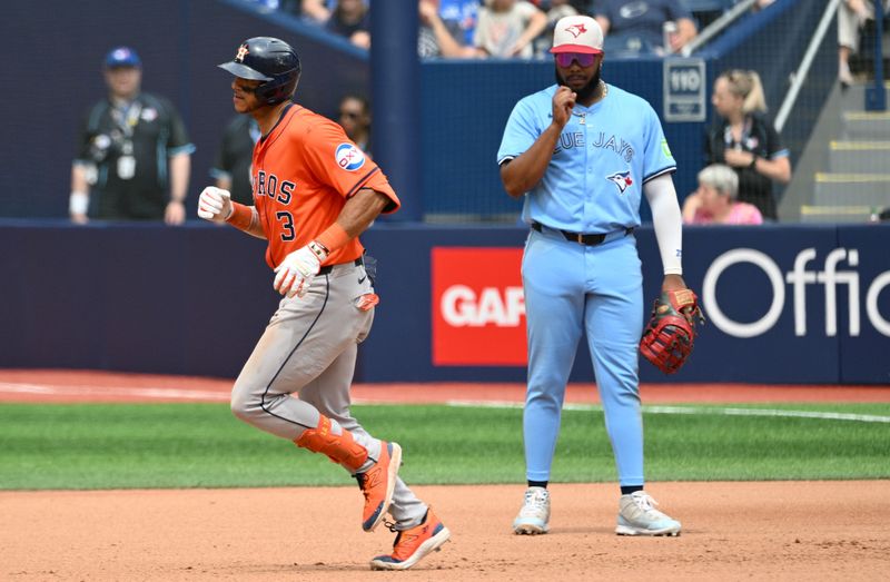 Jul 4, 2024; Toronto, Ontario, CAN; Houston Astros shortstop Jeremy Pena (3) runs past Toronto Blue Jays first baseman Vladimir Guerrero Jr. (27) after hitting a solo home run in the seventh inning at Rogers Centre. Mandatory Credit: Dan Hamilton-USA TODAY Sports