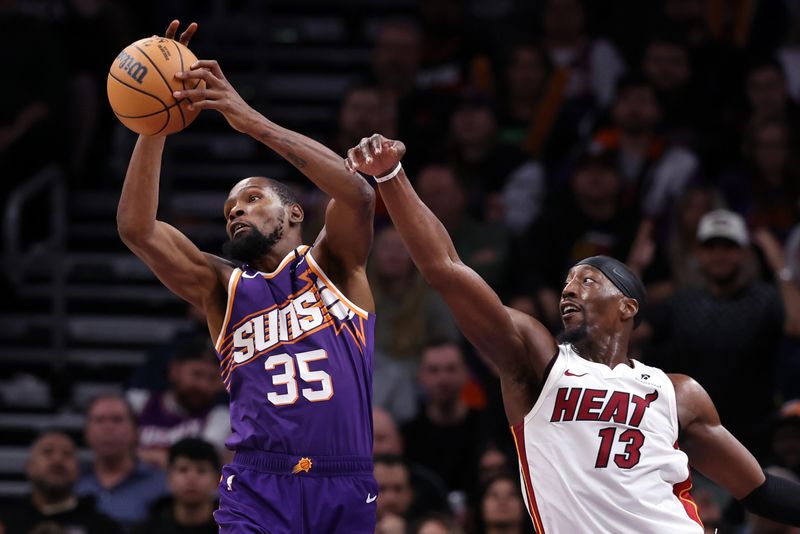 PHOENIX, ARIZONA - NOVEMBER 06: Kevin Durant #35 of the Phoenix Suns controls a rebound over Bam Adebayo #13 of the Miami Heat during the second half at Footprint Center on November 06, 2024 in Phoenix, Arizona. NOTE TO USER: User expressly acknowledges and agrees that, by downloading and or using this photograph, User is consenting to the terms and conditions of the Getty Images License Agreement.  (Photo by Chris Coduto/Getty Images)