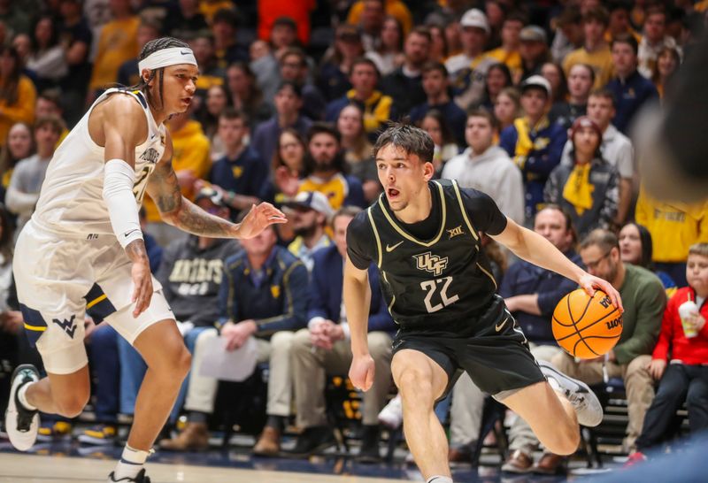 Feb 20, 2024; Morgantown, West Virginia, USA; UCF Knights guard Nils Machowski (22) drives baseline against West Virginia Mountaineers guard RaeQuan Battle (21) during the first half at WVU Coliseum. Mandatory Credit: Ben Queen-USA TODAY Sports