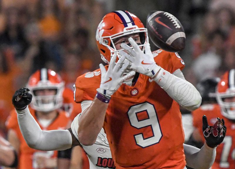 Nov 2, 2024; Clemson, South Carolina, USA; Clemson Tigers tight end Jake Briningstool (9) bobbles and misses a ball against Louisville Cardinals linebacker Antonio Watts (35) during the second quarter at Memorial Stadium. Mandatory Credit: Ken Ruinard-Imagn Images