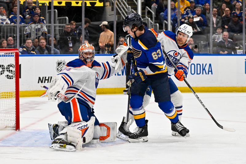 Feb 15, 2024; St. Louis, Missouri, USA;  Edmonton Oilers goaltender Stuart Skinner (74) defends the net against St. Louis Blues left wing Jake Neighbours (63) during the second period at Enterprise Center. Mandatory Credit: Jeff Curry-USA TODAY Sports