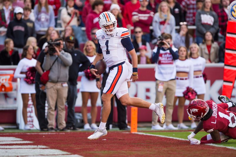 Nov 11, 2023; Fayetteville, Arkansas, USA;  Auburn Tigers quarterback Payton Thorne (1) scores a touchdown and looks back at Arkansas Razorbacks defensive back Lorando Johnson (1) during the first quarter at Donald W. Reynolds Razorback Stadium. Mandatory Credit: Brett Rojo-USA TODAY Sports