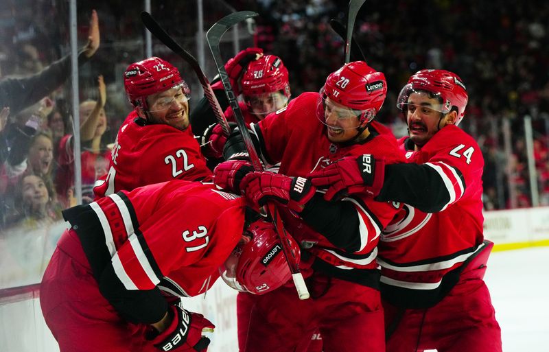 Nov 26, 2023; Raleigh, North Carolina, USA; Carolina Hurricanes right wing Andrei Svechnikov (37) is congratulated by center Sebastian Aho (20) defenseman Brett Pesce (22), center Seth Jarvis (24), and defenseman Brady Skjei (76) after his goal against the Columbus Blue Jackets during the third period at PNC Arena. Mandatory Credit: James Guillory-USA TODAY Sports