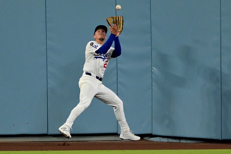 Sep 17, 2025; Los Angeles, California, USA;  Los Angeles Dodgers center fielder Tommy Edman (25) makes a catch at the wall off a ball hit by Philadelphia Phillies catcher J.T. Realmuto (10) in the seventh inning at Dodger Stadium. Mandatory Credit: Jayne Kamin-Oncea-Imagn Images
