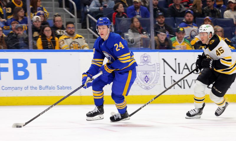 Apr 6, 2025; Buffalo, New York, USA;  Buffalo Sabres defenseman Jacob Bernard-Docker (24) looks to make a pass as Boston Bruins left wing Cole Koepke (45) tries to defend during the first period at KeyBank Center. Mandatory Credit: Timothy T. Ludwig-Imagn Images