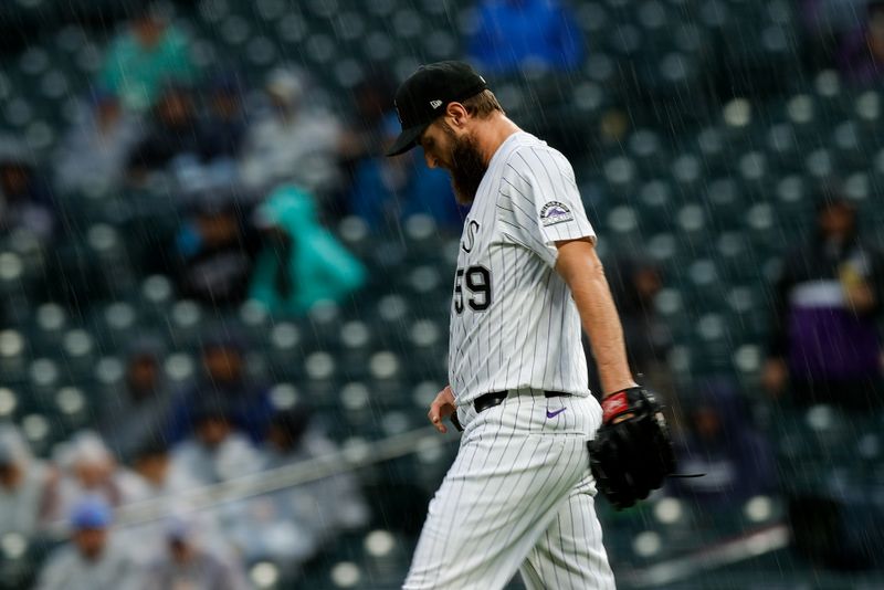 May 25, 2025; Denver, Colorado, USA; Colorado Rockies relief pitcher Jake Bird (59) walks to the mound as rain falls in the fifth inning against the New York Yankees at Coors Field. Mandatory Credit: Isaiah J. Downing-Imagn Images