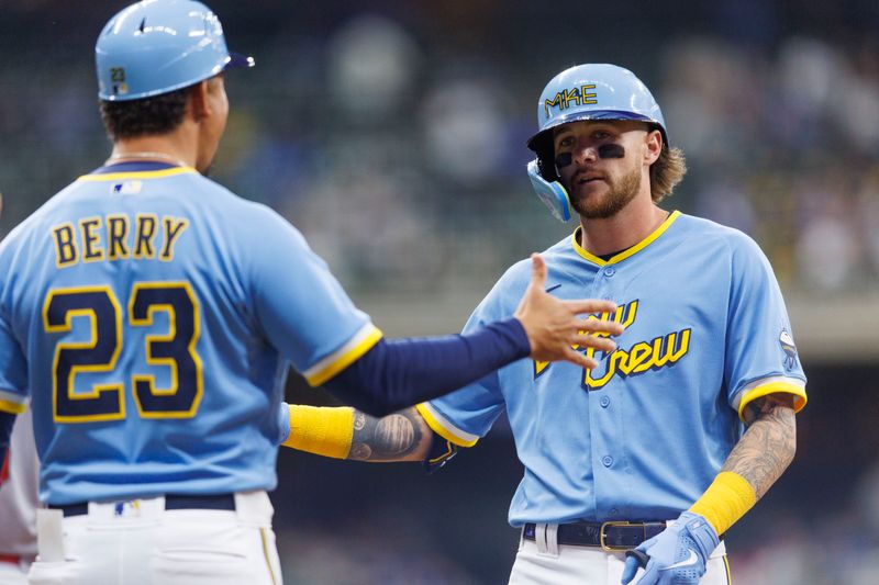 Apr 7, 2023; Milwaukee, Wisconsin, USA;  Milwaukee Brewers second baseman Brice Turang (0) is greeted by first base coach Quinton Berry (23) during the sixth inning against the St. Louis Cardinals at American Family Field. Mandatory Credit: Jeff Hanisch-USA TODAY Sports