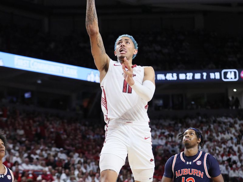 Jan 6, 2024; Fayetteville, Arkansas, USA; Arkansas Razorbacks forward Jalen Graham (11) shoots in the second half as Auburn Tigers guard Denver Jones (12) looks on at Bud Walton Arena. Auburn won 83-51. Mandatory Credit: Nelson Chenault-USA TODAY Sports