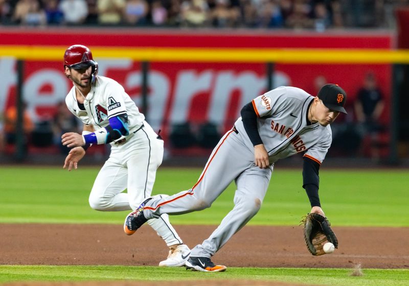 Sep 16, 2025; Phoenix, Arizona, USA; San Francisco Giants first baseman Wilmer Flores (right) fields a ground by as Arizona Diamondbacks base runner Blaze Alexander runs past in the seventh inning at Chase Field. Mandatory Credit: Mark J. Rebilas-Imagn Images