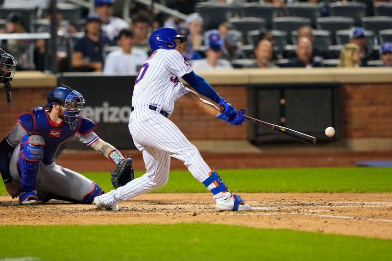 Aug 30, 2023; New York City, New York, USA;  New York Mets left fielder Rafael Ortega (30) hits a single against the Texas Rangers during the fourth inning at Citi Field. Mandatory Credit: Gregory Fisher-USA TODAY Sports